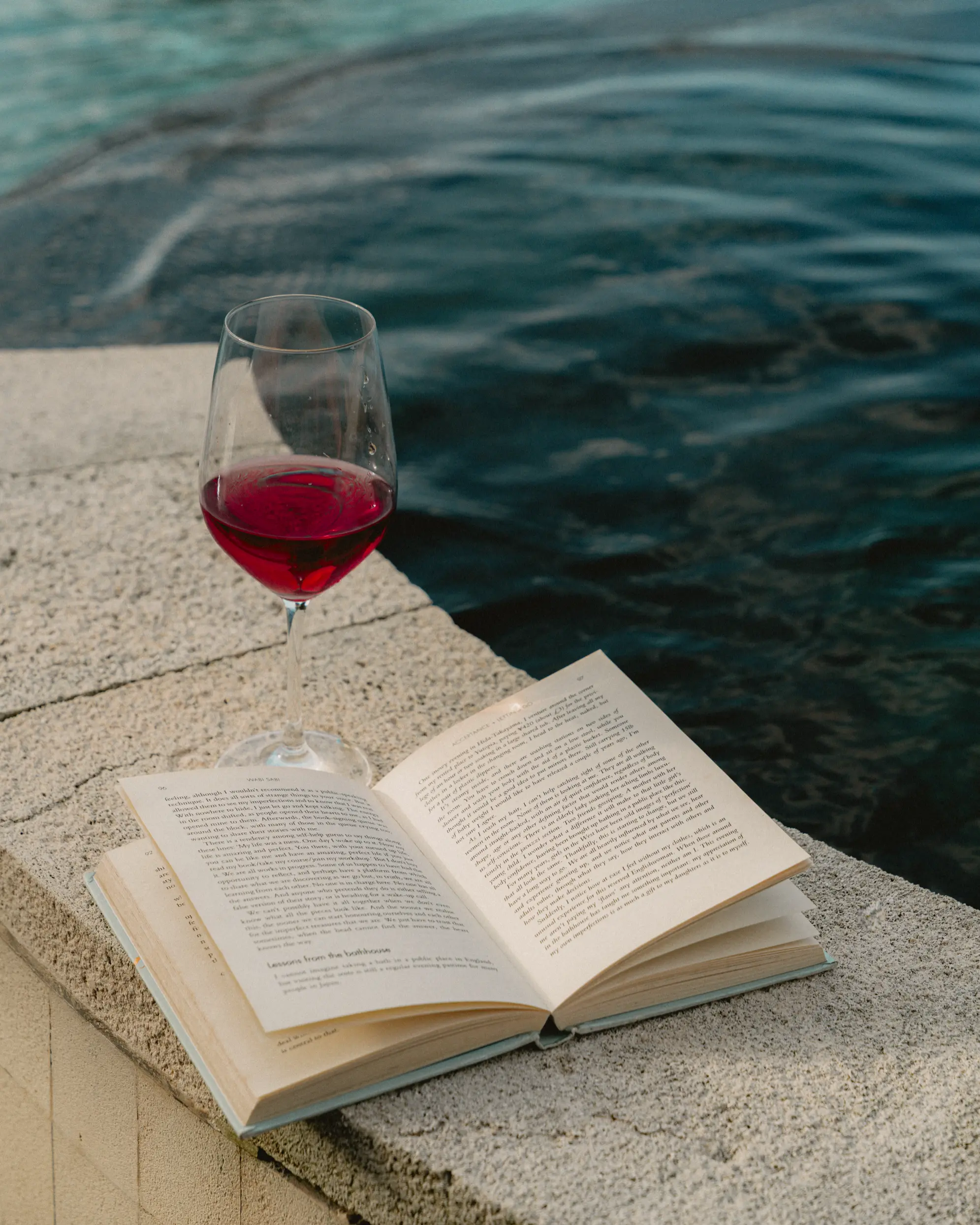 Wine and a book at the edge of a jacuzzi